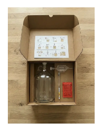 The BrewKit Lab 1 Gallon Brewing Kit — open box with fermenter, airlock, sanitizer, and instruction card